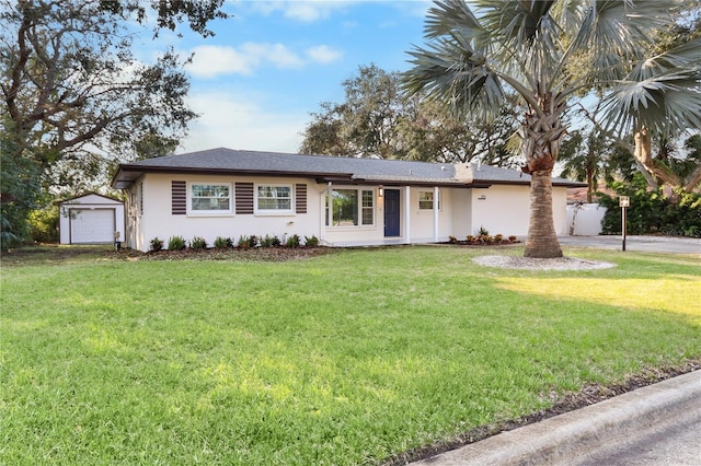 single story home featuring a front lawn, an outbuilding, and a garage