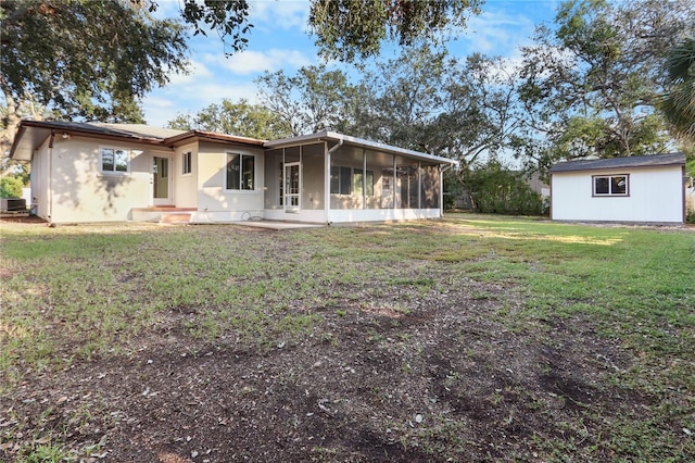 rear view of property featuring a yard and a sunroom