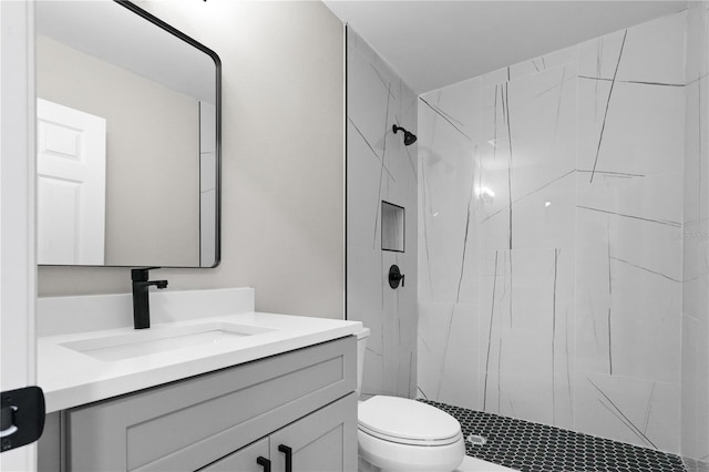 bathroom featuring vanity, toilet, and tiled shower