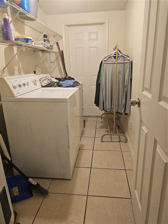 clothes washing area featuring light tile patterned floors and washing machine and clothes dryer