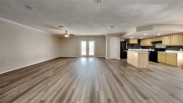 kitchen with a kitchen island, a textured ceiling, black refrigerator, electric stove, and light hardwood / wood-style floors