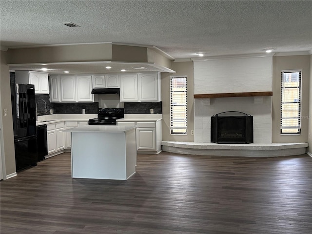 kitchen featuring white cabinets, dark hardwood / wood-style flooring, a kitchen island, and black appliances