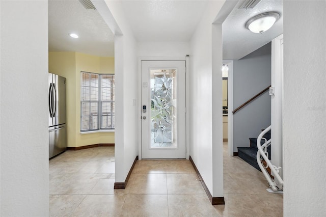 tiled foyer entrance featuring a textured ceiling