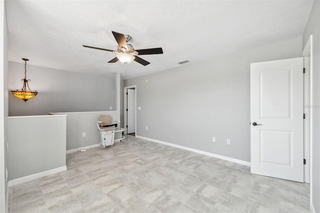 empty room featuring a textured ceiling and ceiling fan