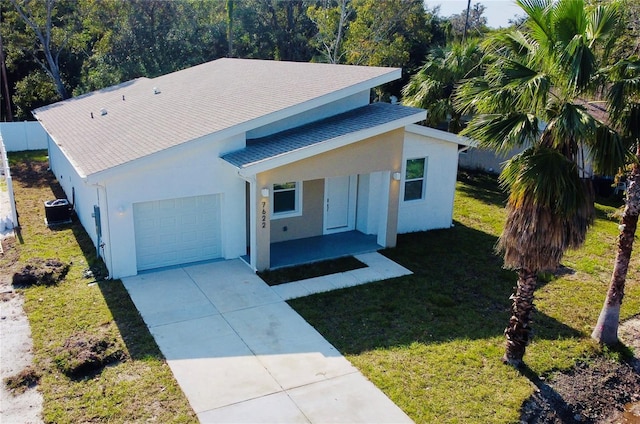 view of front facade featuring cooling unit, a porch, a front yard, and a garage