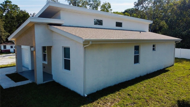 view of side of property with a lawn and a patio area