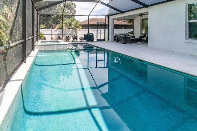 view of swimming pool with outdoor lounge area, a patio area, glass enclosure, and ceiling fan