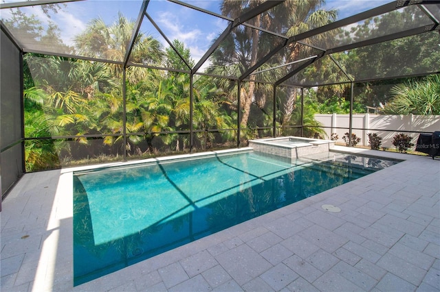 view of swimming pool featuring a patio area, glass enclosure, and a jacuzzi