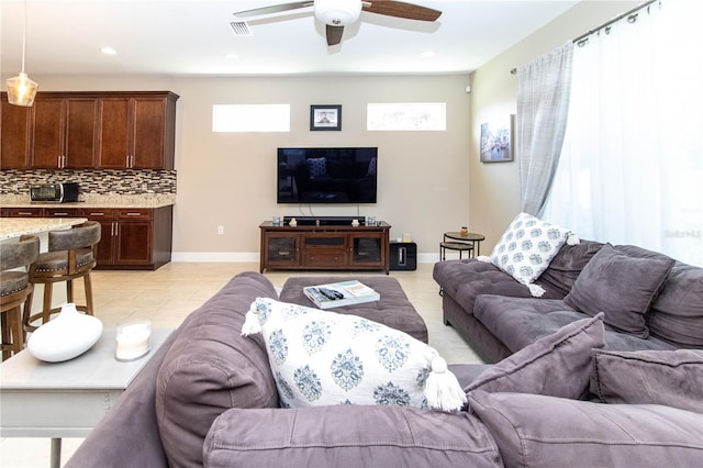 living room with ceiling fan, light tile patterned floors, and plenty of natural light