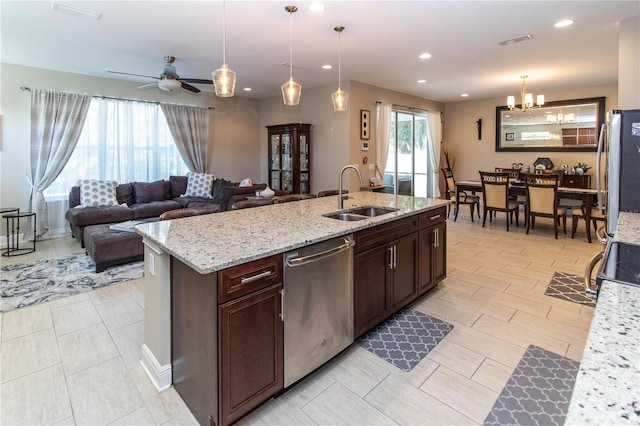 kitchen featuring sink, ceiling fan with notable chandelier, hanging light fixtures, stainless steel appliances, and dark brown cabinetry