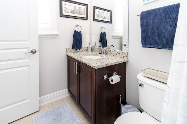 bathroom featuring a healthy amount of sunlight, vanity, and toilet