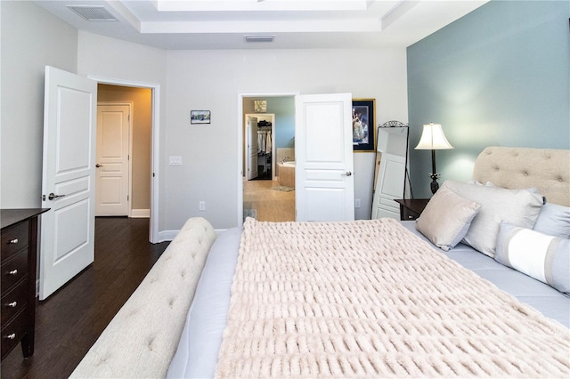 bedroom featuring a raised ceiling and wood-type flooring