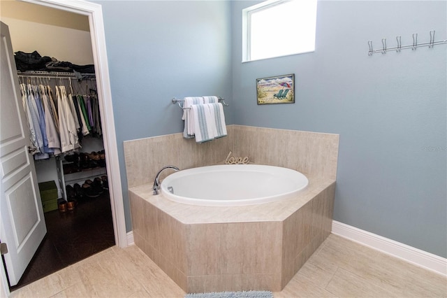 bathroom with tile patterned floors and tiled tub