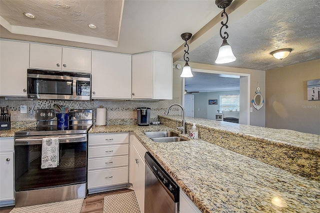 kitchen featuring white cabinetry, stainless steel appliances, decorative light fixtures, and decorative backsplash