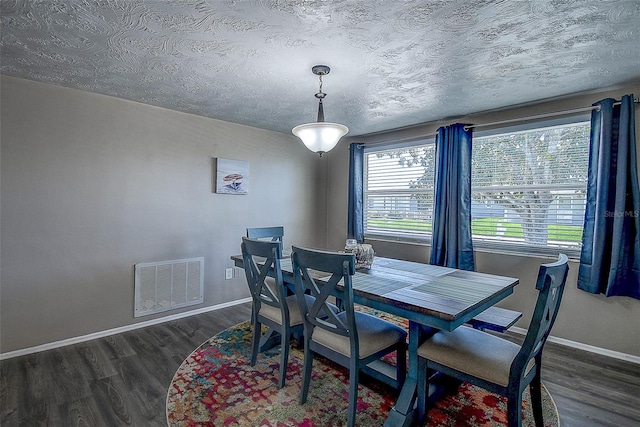 dining area with dark hardwood / wood-style floors and a textured ceiling