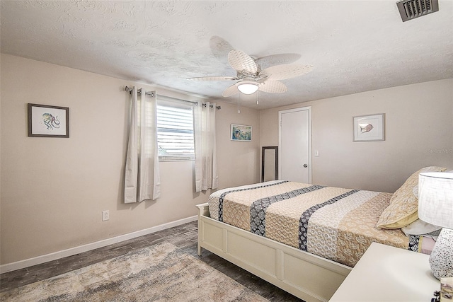 bedroom with hardwood / wood-style flooring, ceiling fan, and a textured ceiling