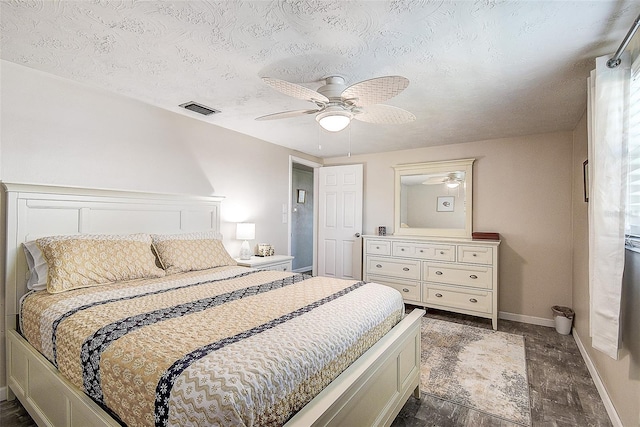 bedroom with ceiling fan and a textured ceiling