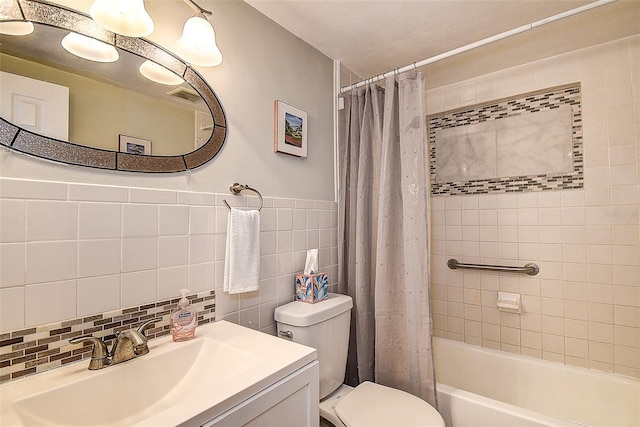 full bathroom featuring shower / bathtub combination with curtain, vanity, tile walls, and toilet