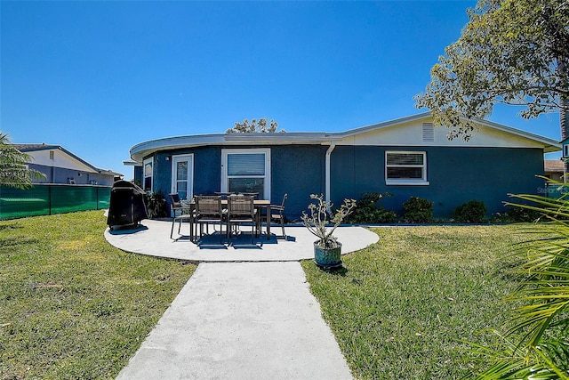 back of property featuring a lawn and a patio area