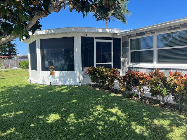 view of side of property with a yard and a sunroom