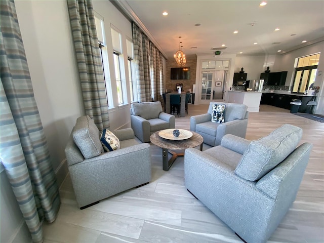 living room with ornamental molding and a chandelier