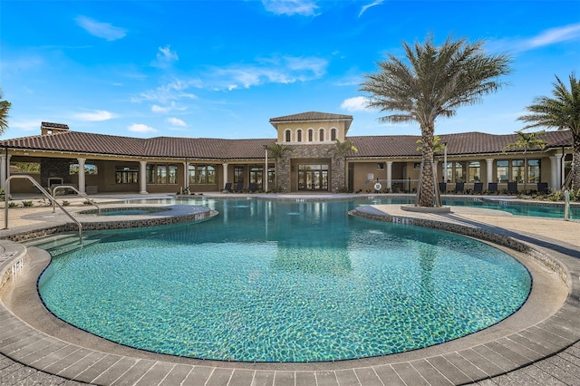 view of swimming pool featuring a patio and a hot tub