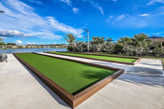 view of property's community with a bocce ball area and a water view
