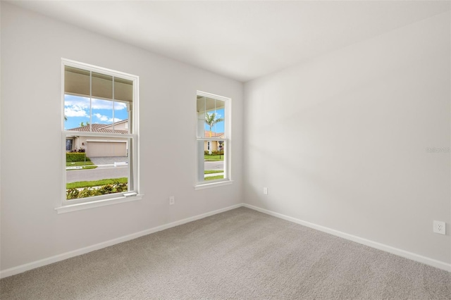 unfurnished room featuring carpet flooring and baseboards