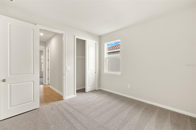 unfurnished bedroom featuring carpet flooring, baseboards, and a closet