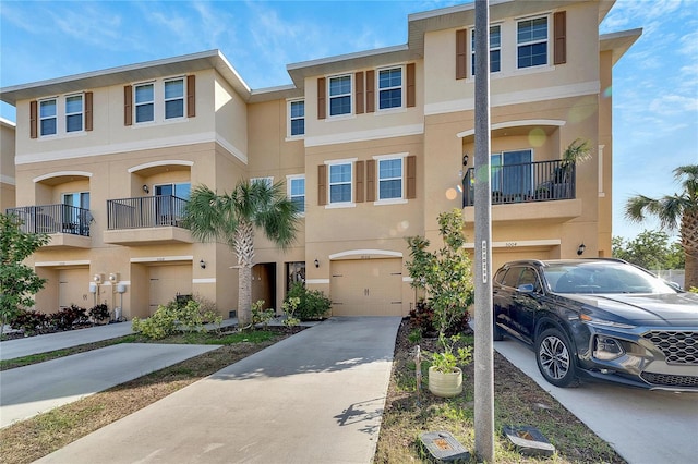 townhome / multi-family property featuring a balcony and a garage