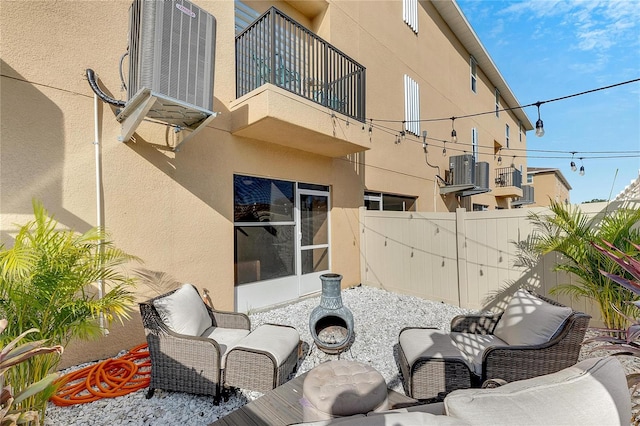 view of patio with central air condition unit and a balcony