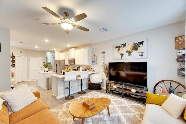 living room featuring light hardwood / wood-style floors and ceiling fan