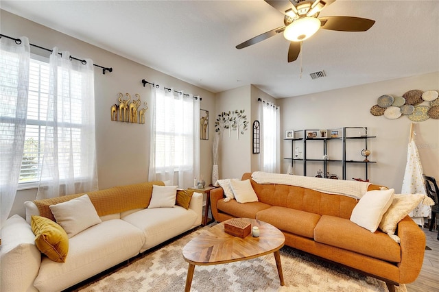 living room with light wood-type flooring and ceiling fan