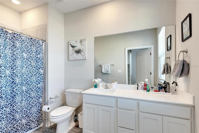 bathroom featuring vanity, a shower with curtain, hardwood / wood-style flooring, and toilet