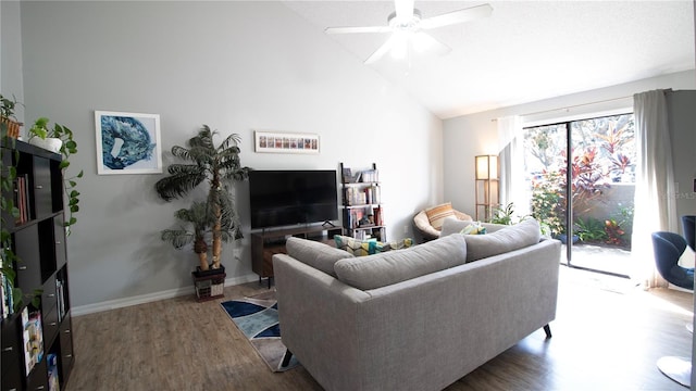 living room with hardwood / wood-style flooring, ceiling fan, and vaulted ceiling