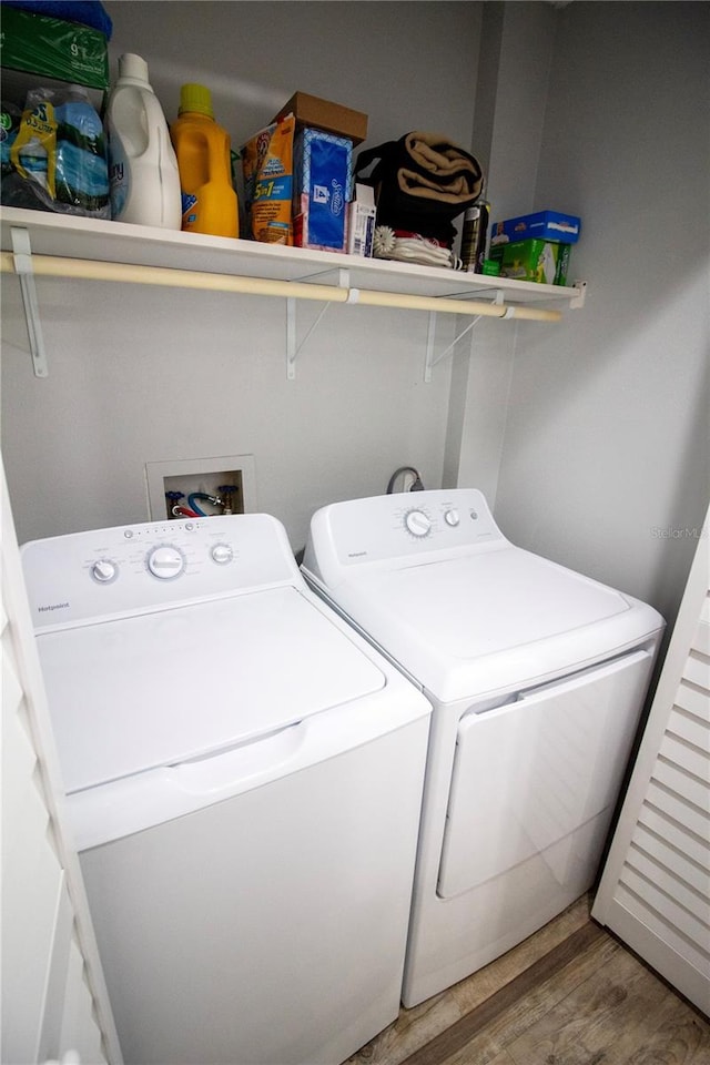 washroom featuring hardwood / wood-style floors and washing machine and clothes dryer