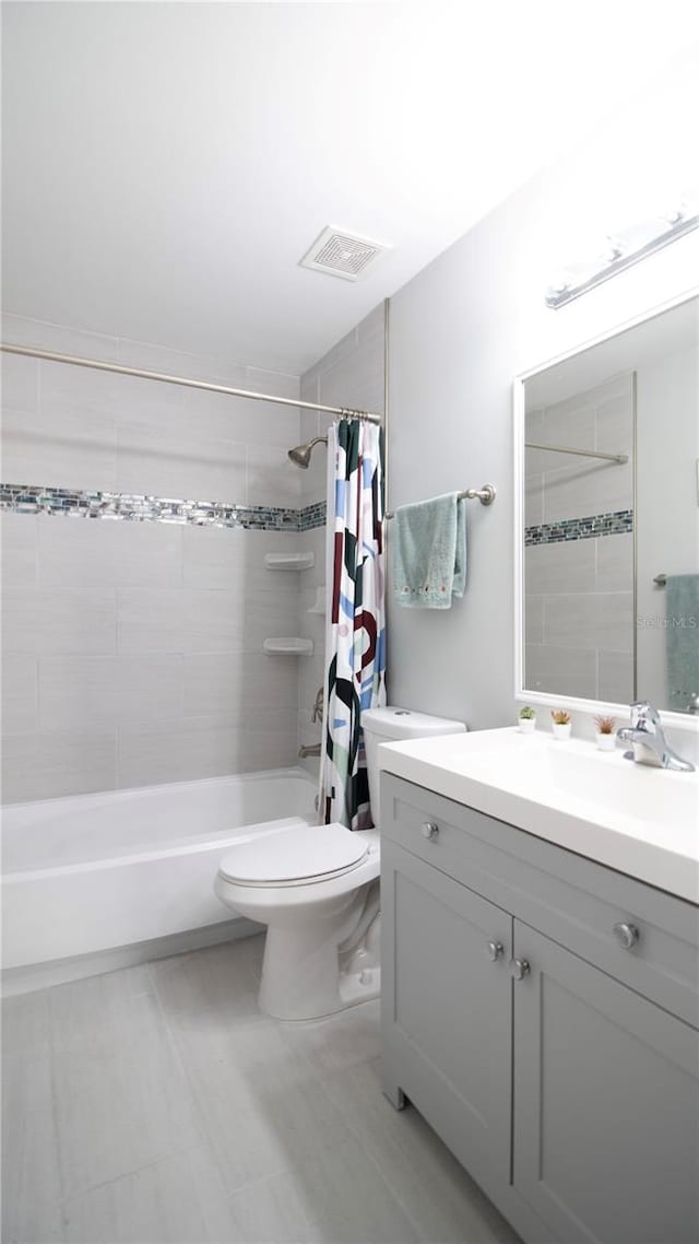 full bathroom featuring vanity, shower / tub combo with curtain, and toilet