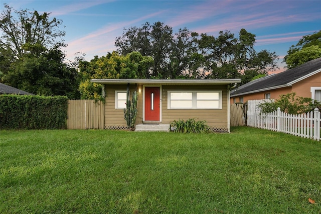 single story home featuring a lawn