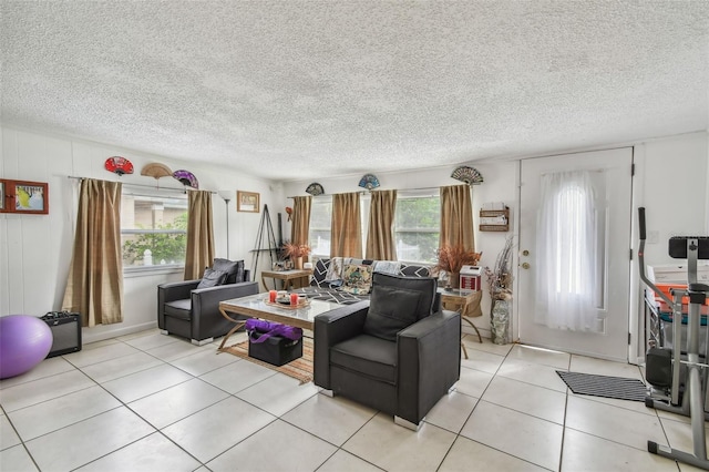 living room with a healthy amount of sunlight, light tile patterned floors, and a textured ceiling