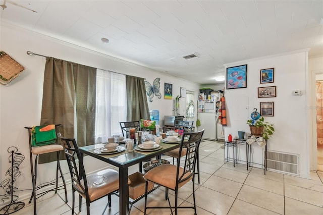 tiled dining area featuring ornamental molding