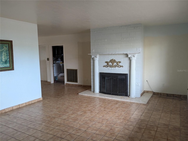 unfurnished living room featuring a fireplace and light tile patterned flooring