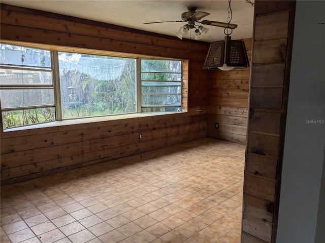 empty room with ceiling fan and wooden walls