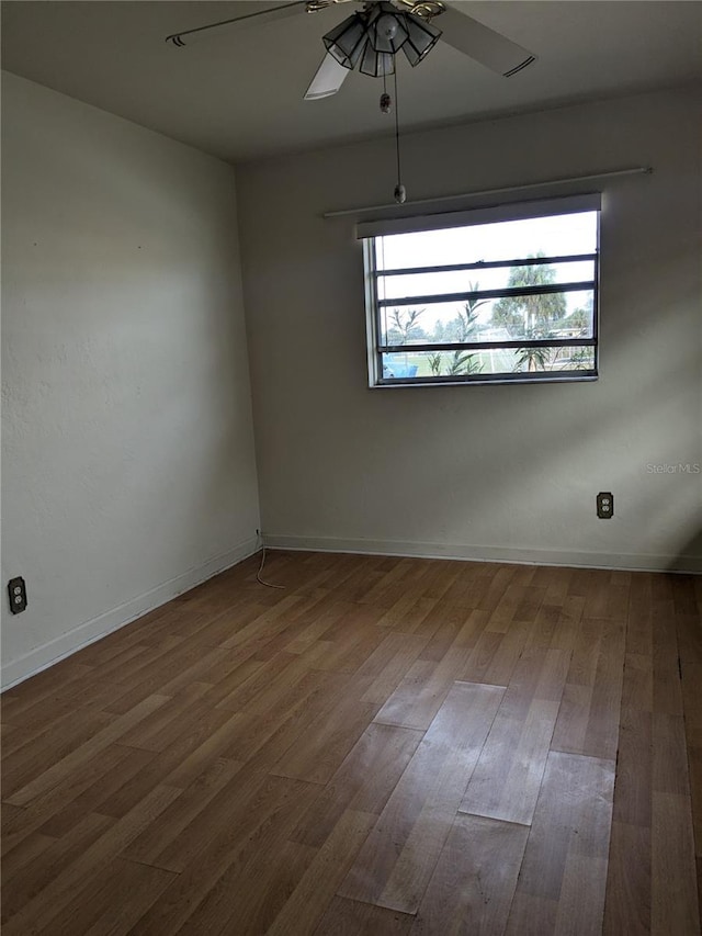 empty room featuring ceiling fan, plenty of natural light, and wood-type flooring