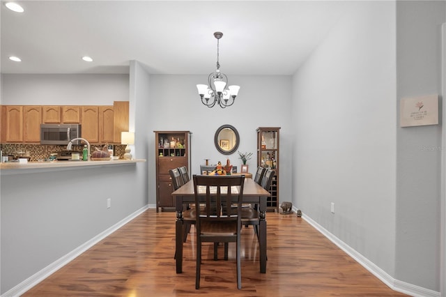 dining area featuring hardwood / wood-style floors and a notable chandelier