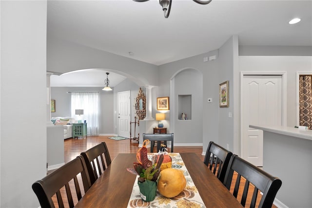 dining area featuring wood-type flooring and ornate columns