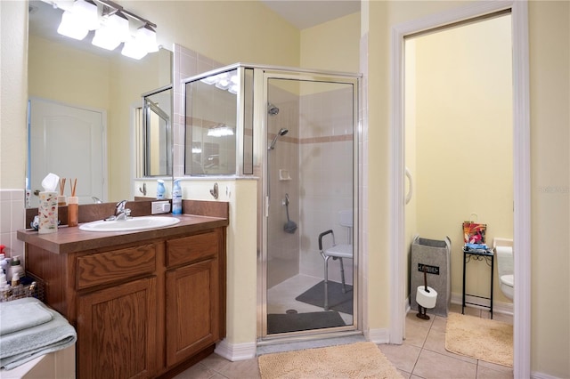 bathroom with tile patterned floors, vanity, an enclosed shower, and toilet