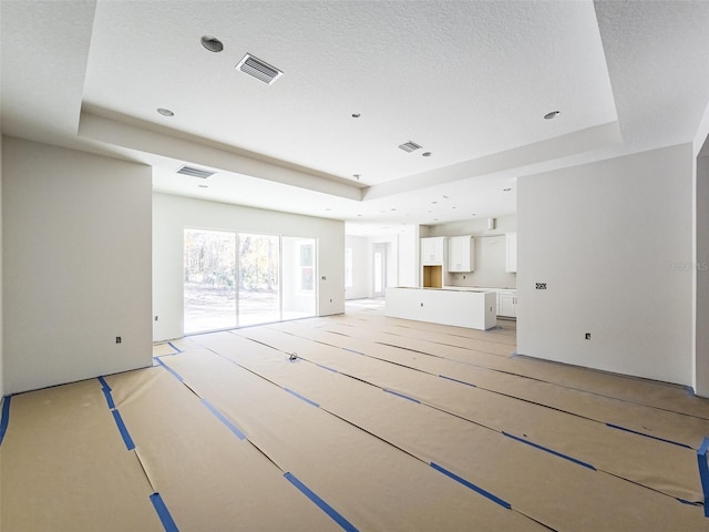 unfurnished living room featuring a raised ceiling