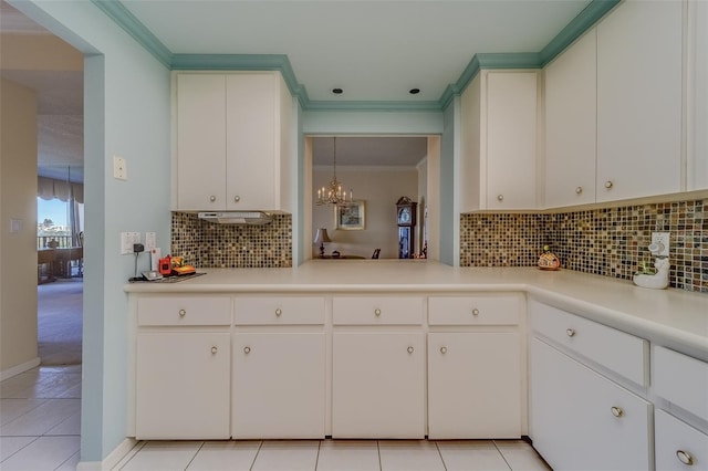 kitchen with white cabinetry, light tile patterned floors, and ornamental molding