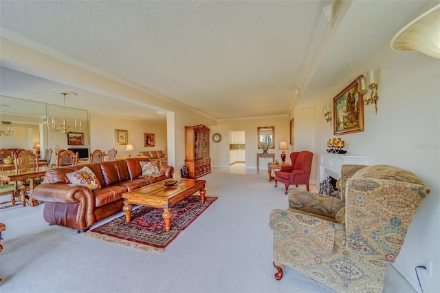 carpeted living room with a notable chandelier, ornamental molding, and a textured ceiling