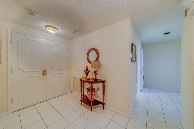 foyer with light tile patterned floors and a textured ceiling